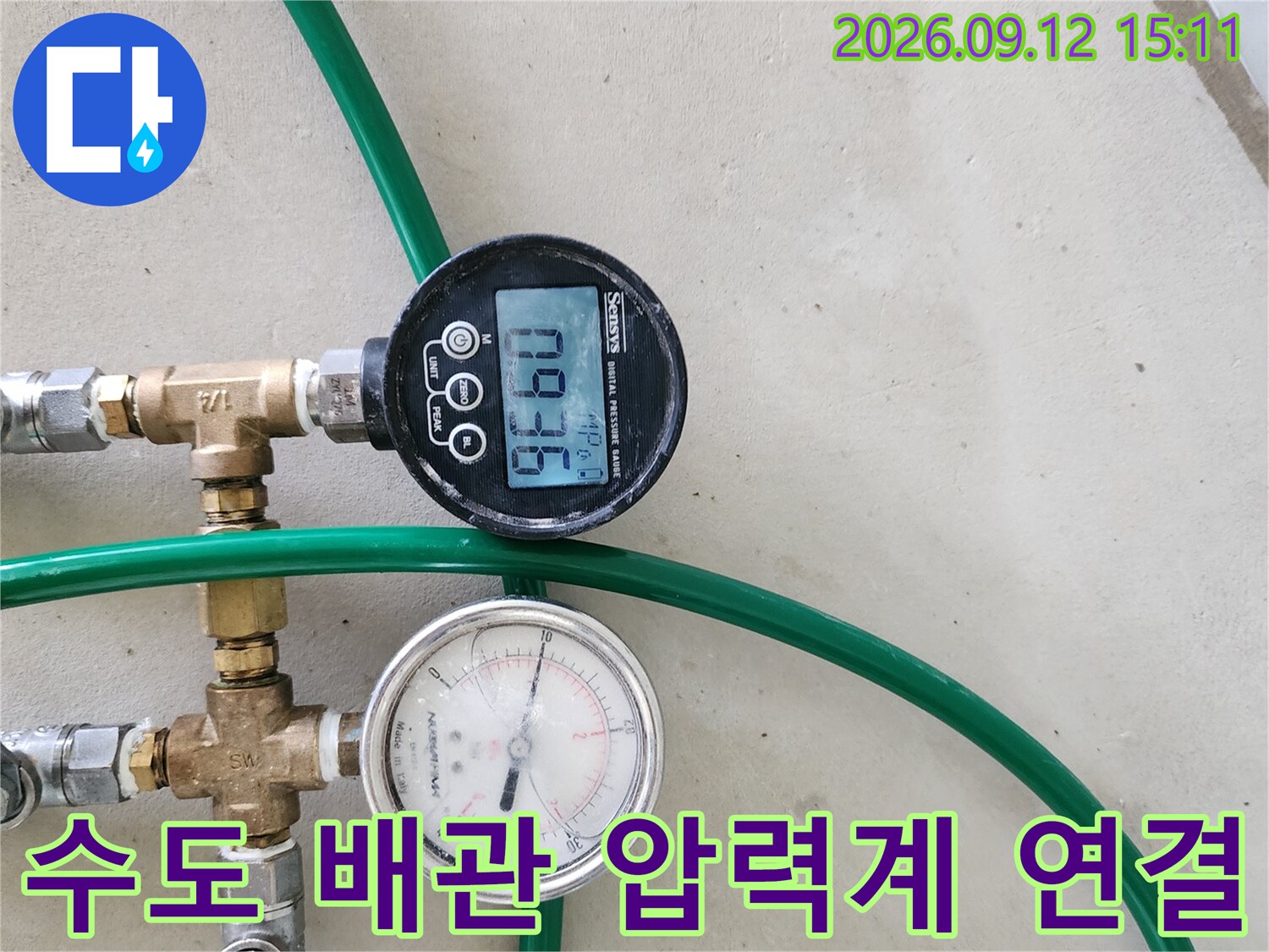 금속 부속과 호스가 연결된 수도 배관의 압력 측정 장비 구성