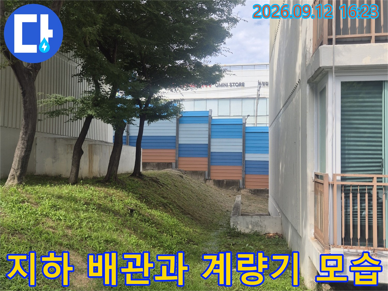 파란색 보온재로 덮인 급수 배관과 옆에 위치한 계량기 시설입니다.