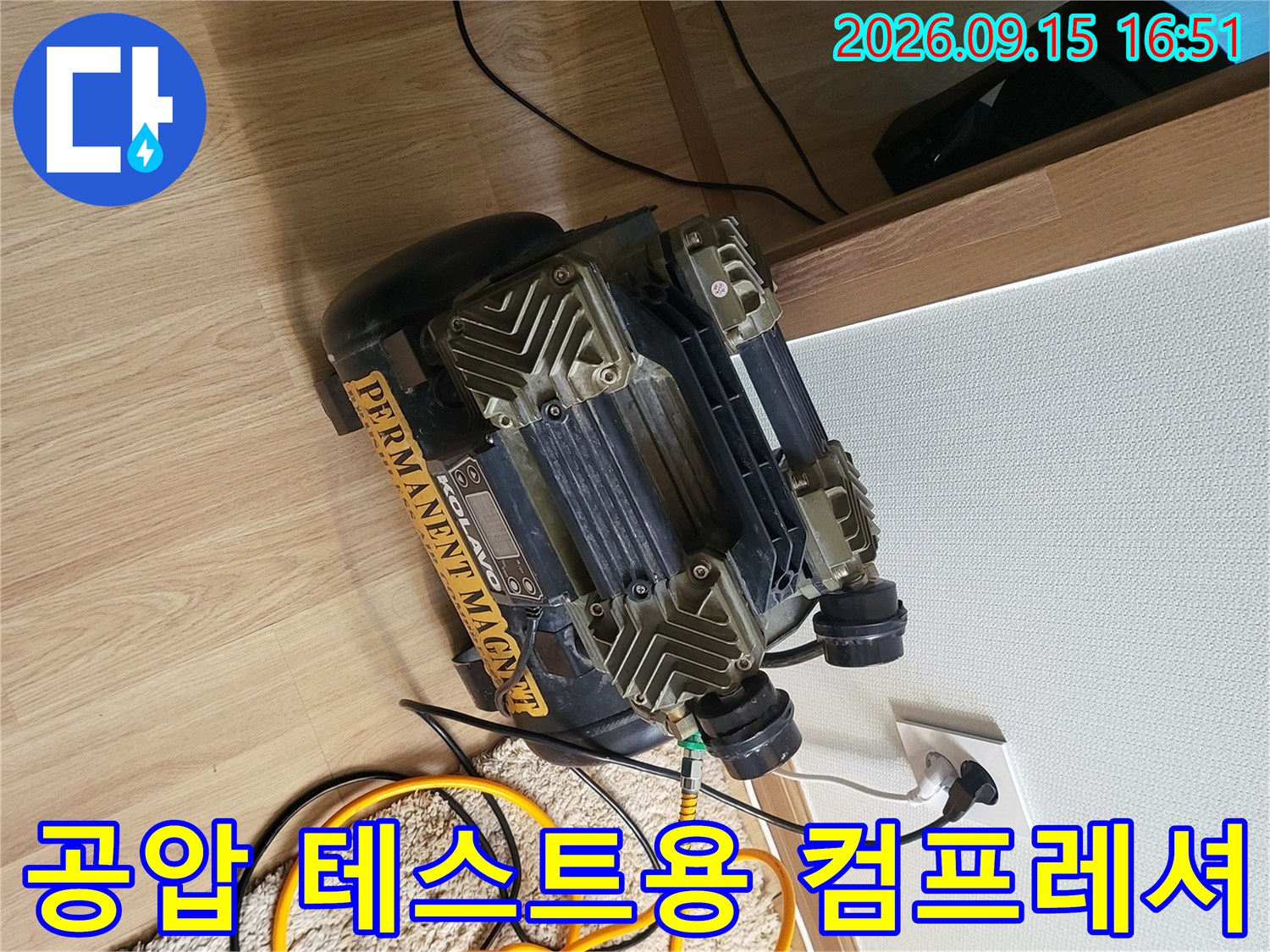 바닥에 놓인 누수 탐지 장비와 연결된 노란색 호스의 모습입니다.