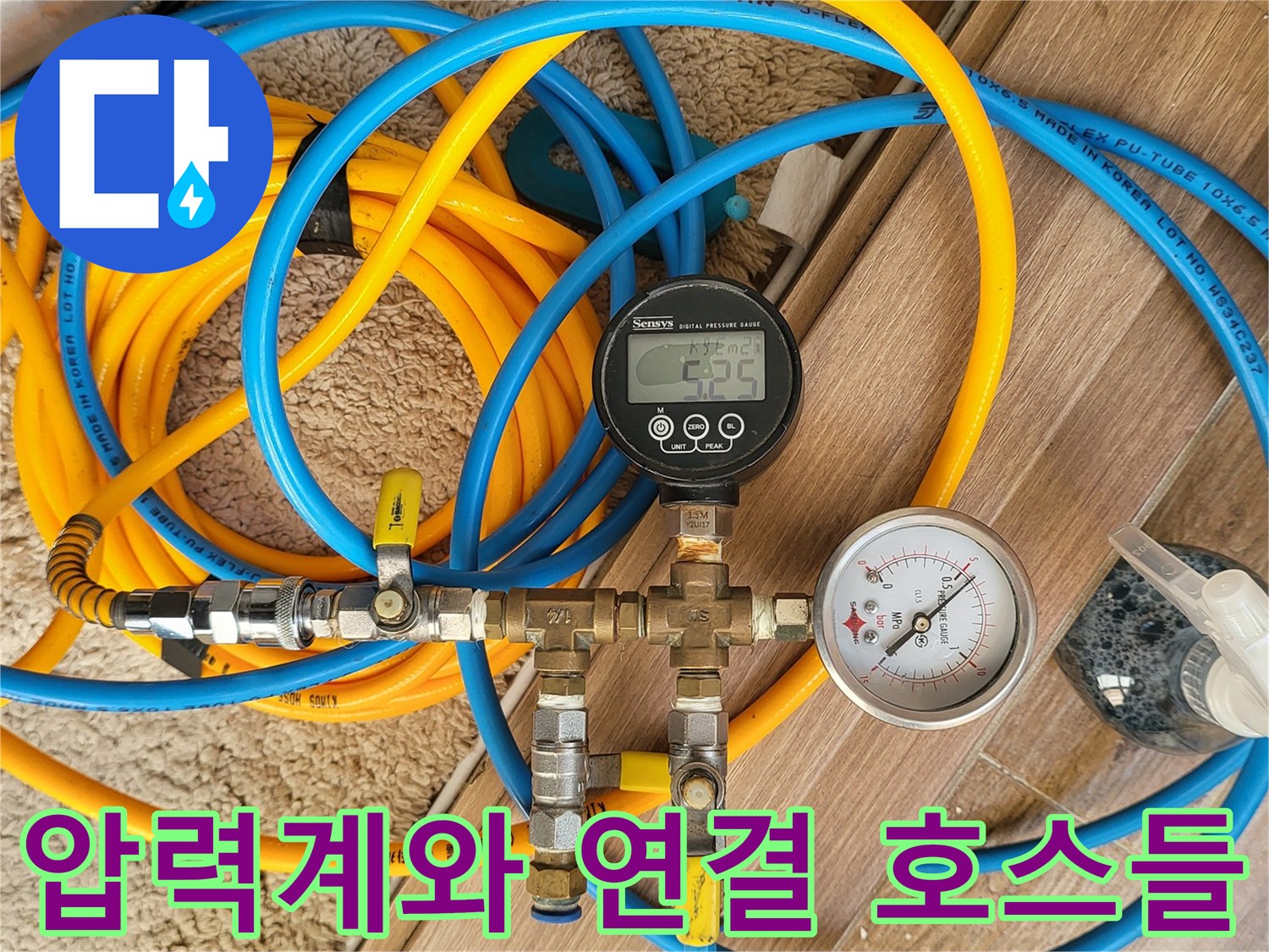 배관의 압력을 체크하기 위해 얽혀 있는 파란색과 노란색 호스 및 게이지