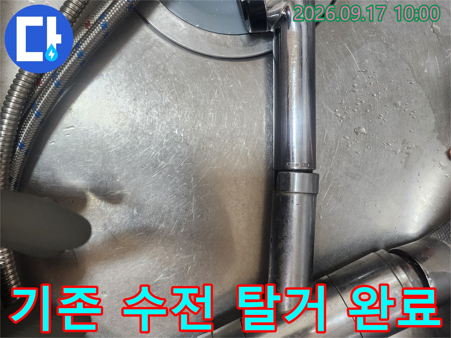 탈거된 싱크대 수전과 은색 배관 호스의 모습입니다.
