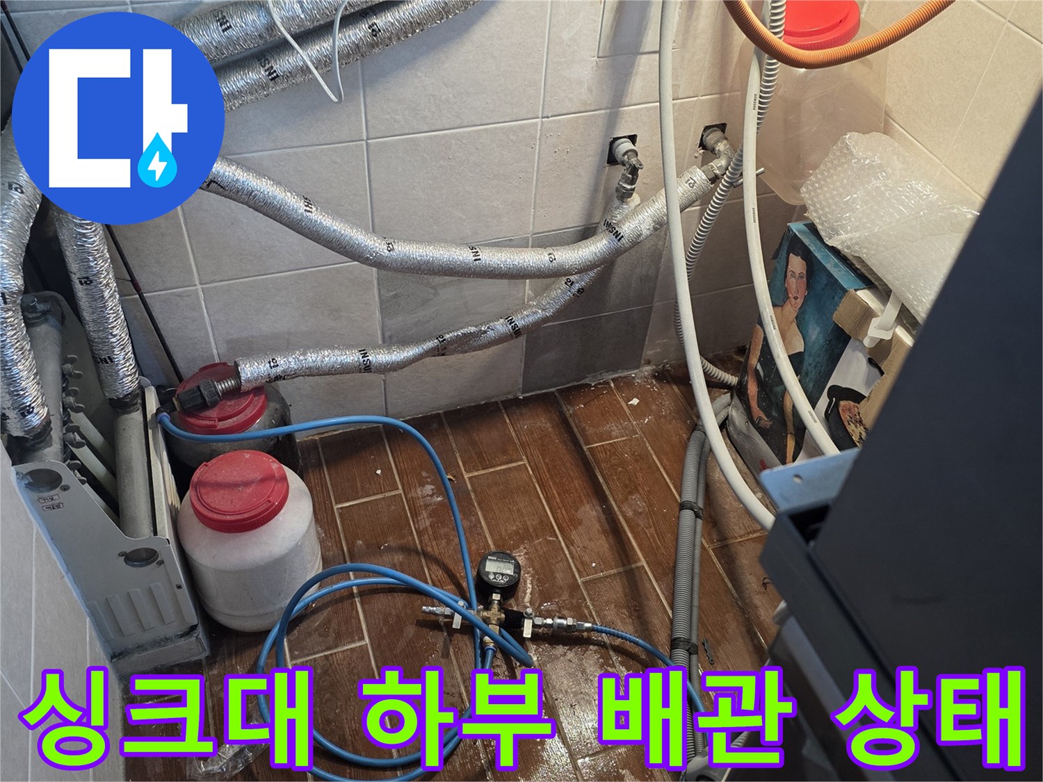 싱크대-하부의-복잡한-배관과-보온재-상태를-보여주는-사진