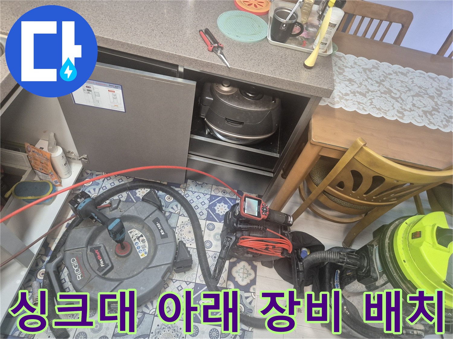 배수구 점검을 위해 싱크대 밑에 놓인 내시상 및 흡입 장치
