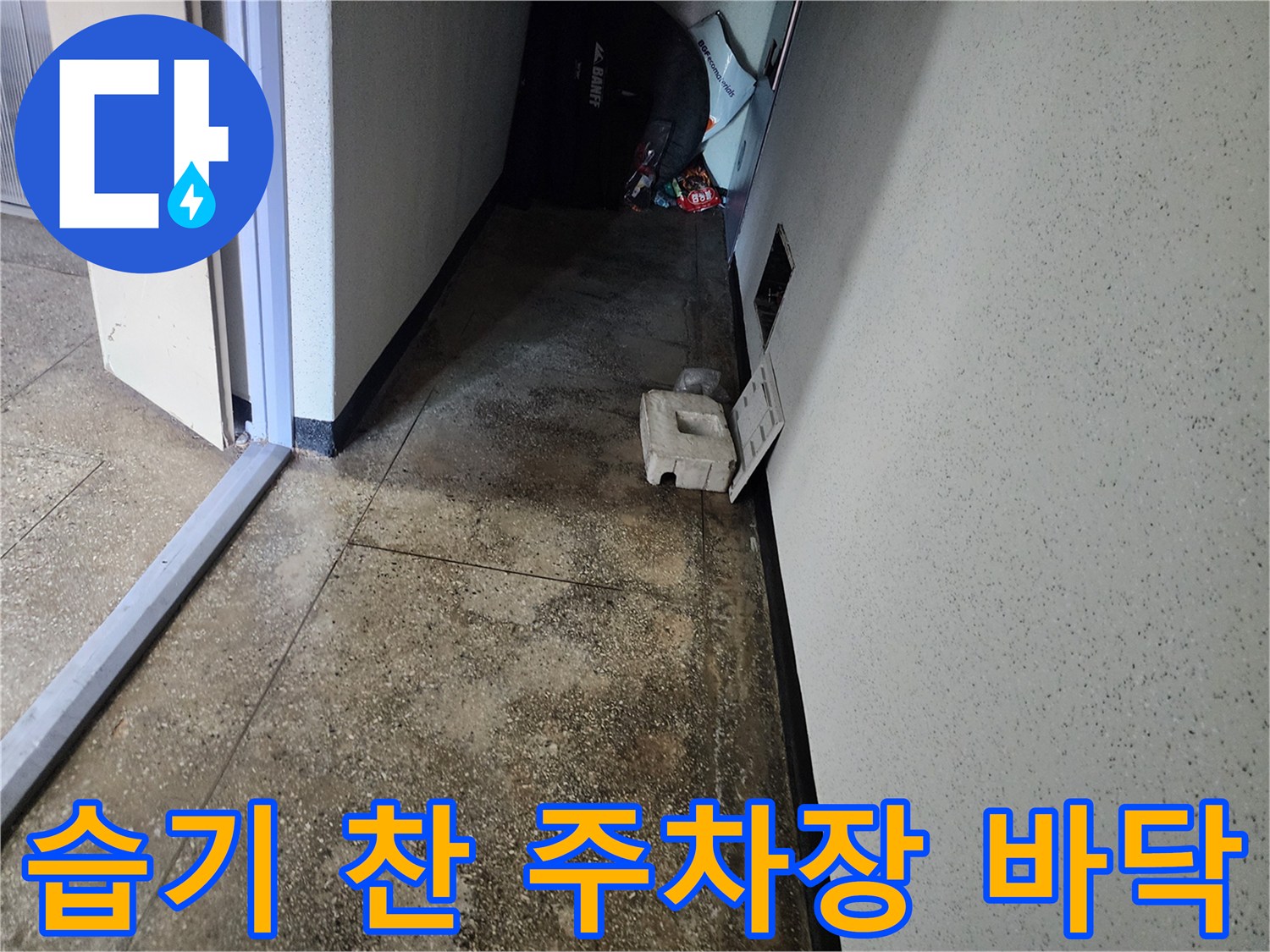물기가 스며들어 어둡게 변한 지하 주차장 타일