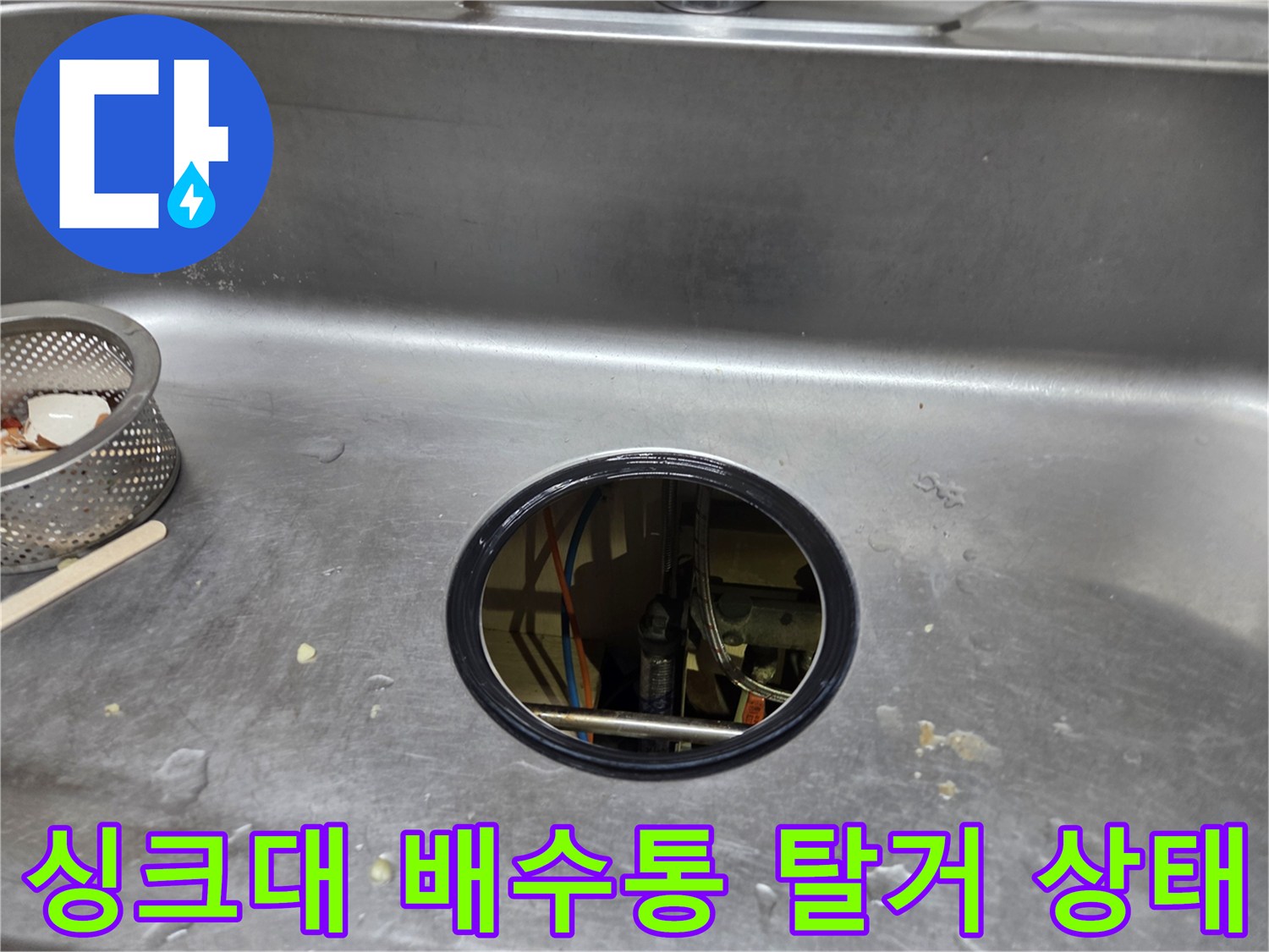 배수통을 제거하여 싱크대 하부의 복잡한 배관 연결 부위가 노출된 사진입니다.