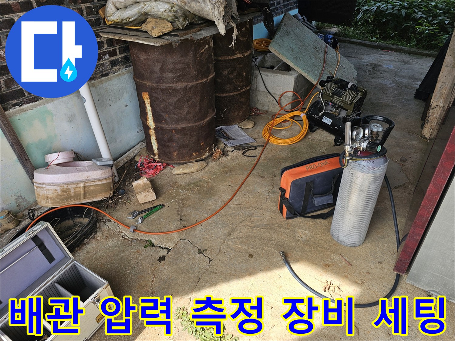 누수 여부를 판단하기 위해 배관에 연결된 압력 게이지와 호스